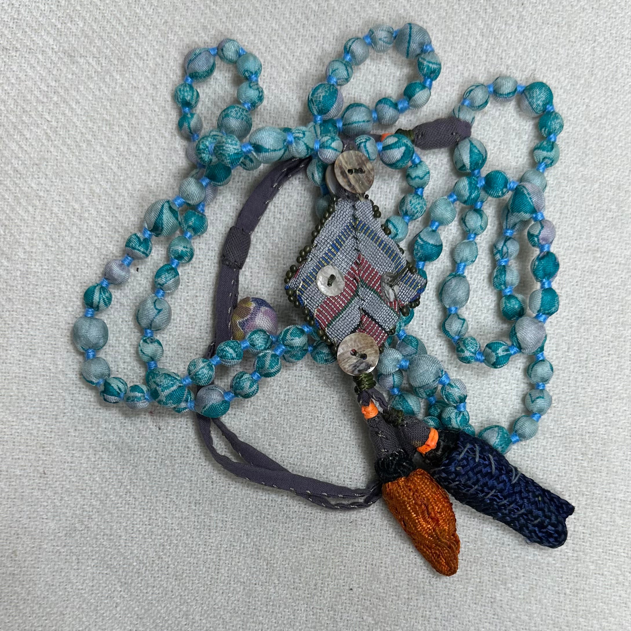 Light blue swirl and tassels in blue and orange